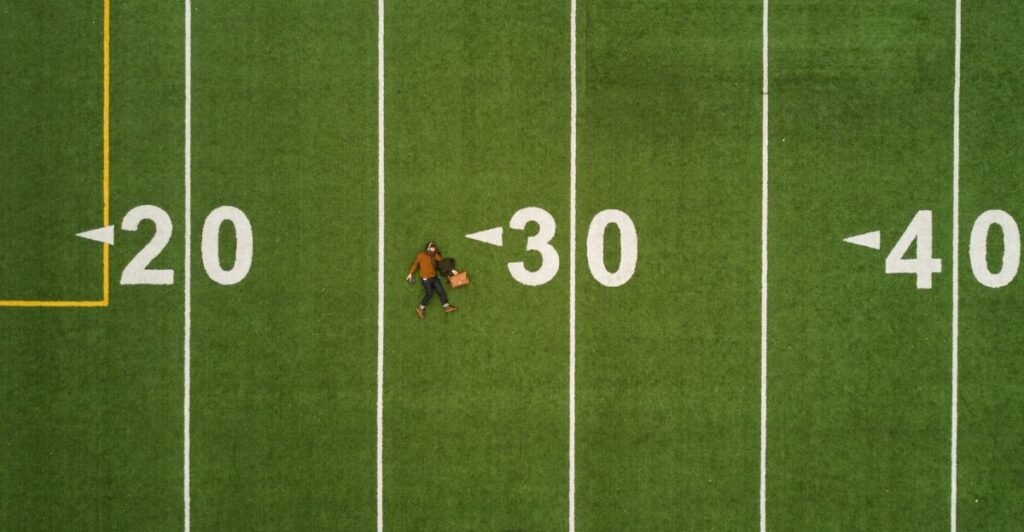 martin-reisch-unsplash -man lying in green soccer field