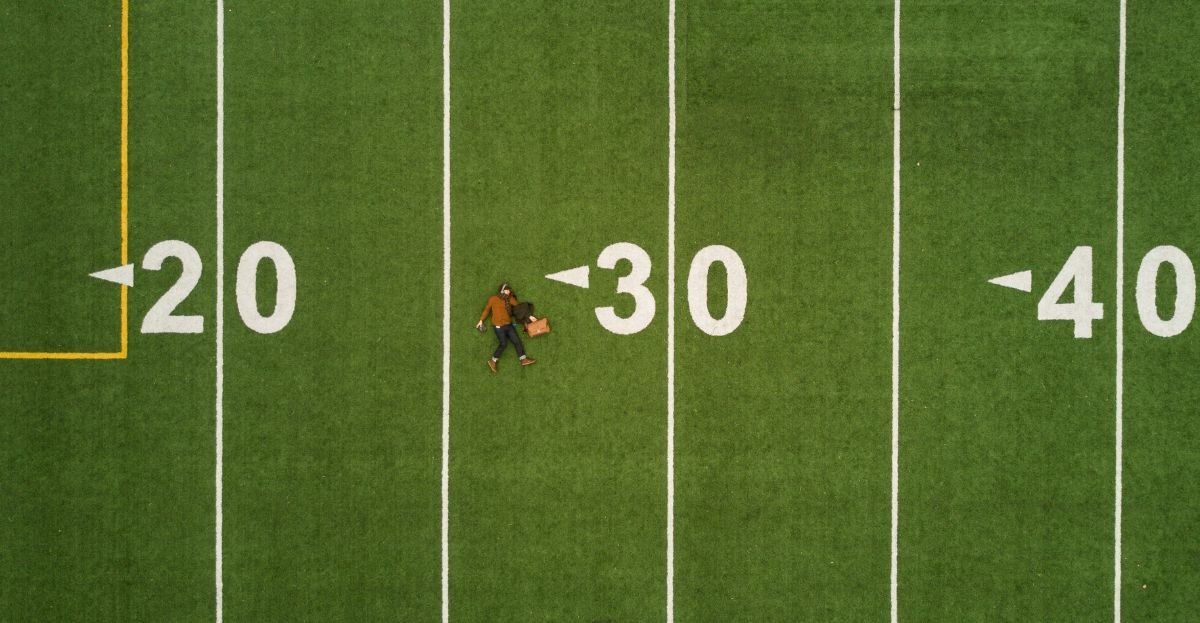 martin-reisch-unsplash -man lying in green soccer field