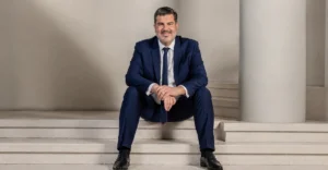 Oriflame Appoints Kenneth Benaim Campbell as Chief Executive Officer in an official portrait wearing a navy blue suit.