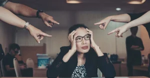 Employee sitting silently in a video meeting, showing second-language anxiety at work in a global team