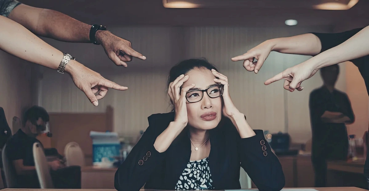 Employee sitting silently in a video meeting, showing second-language anxiety at work in a global team